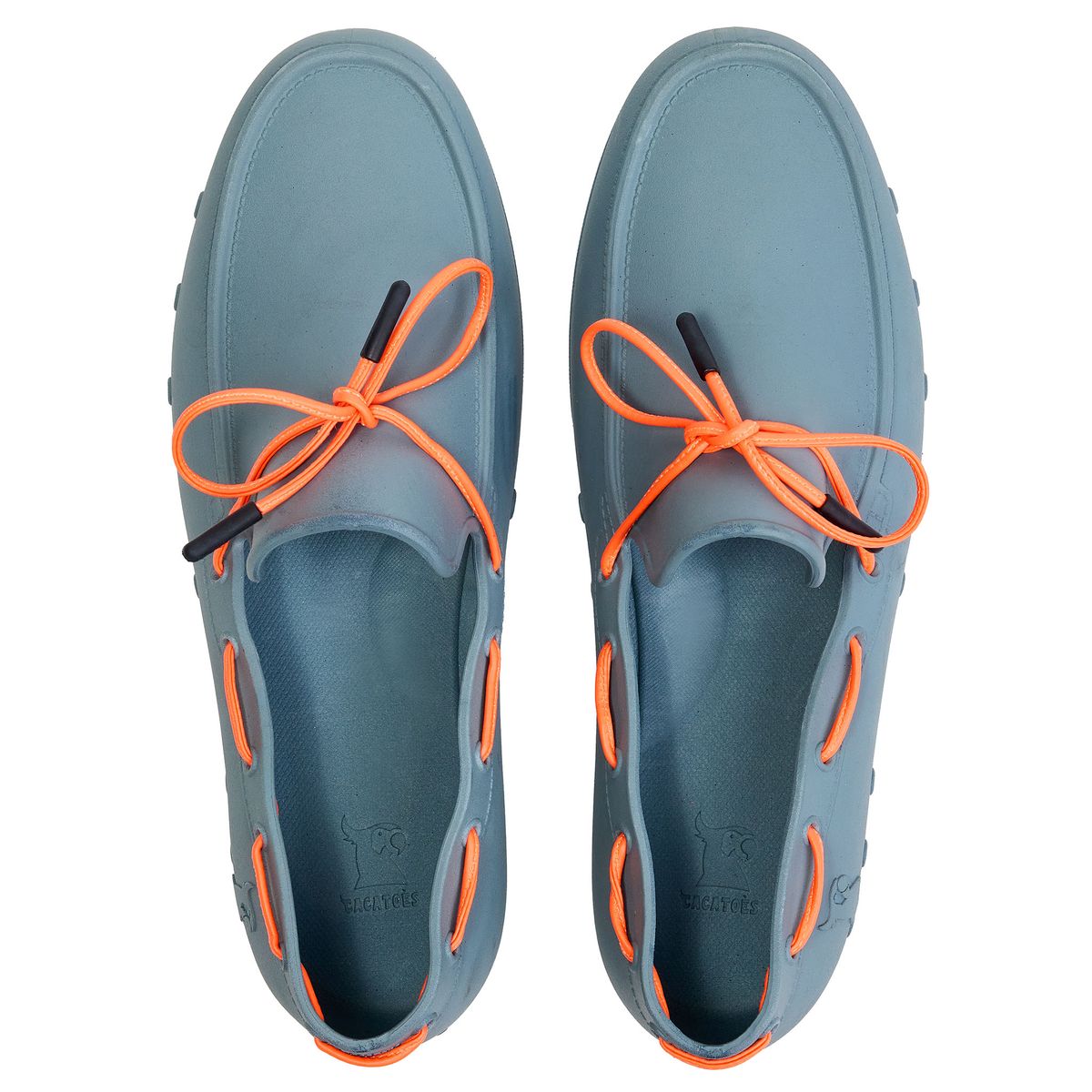 Des chaussures en caoutchouc gris sont posées sur une surface blanche. Les lacets orange sont bien visibles et ajoutent un contraste. Les chaussures semblent confortables et adaptées pour l'été.
